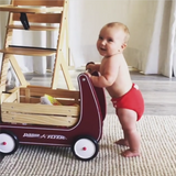 Baby pushing wagon in red modern cloth nappy